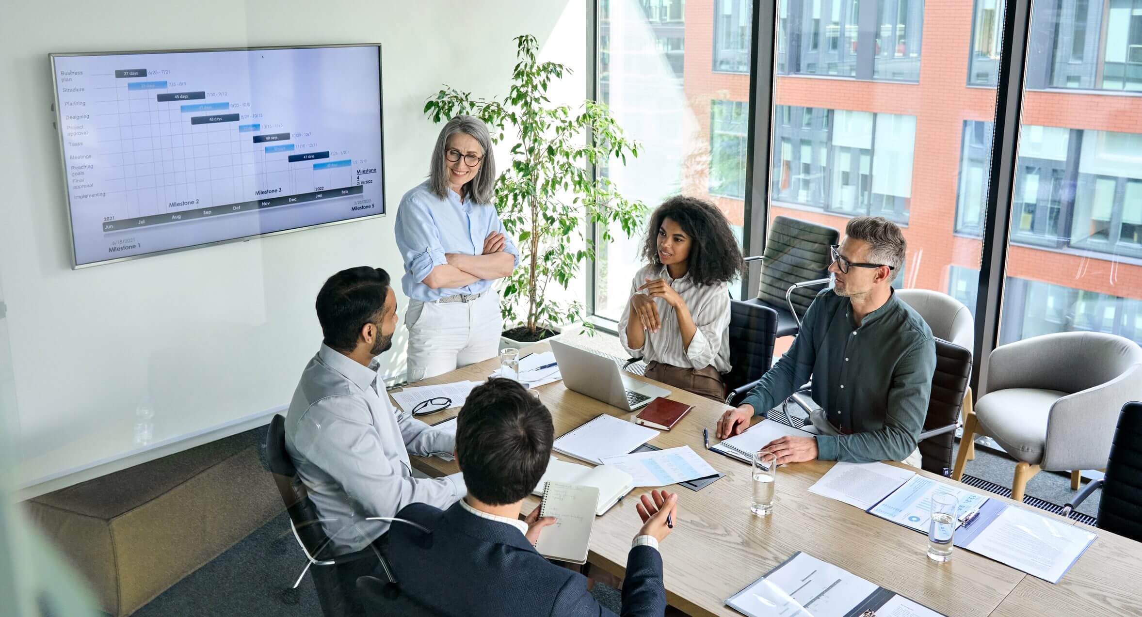 Office meeting with presentation on wall screen.