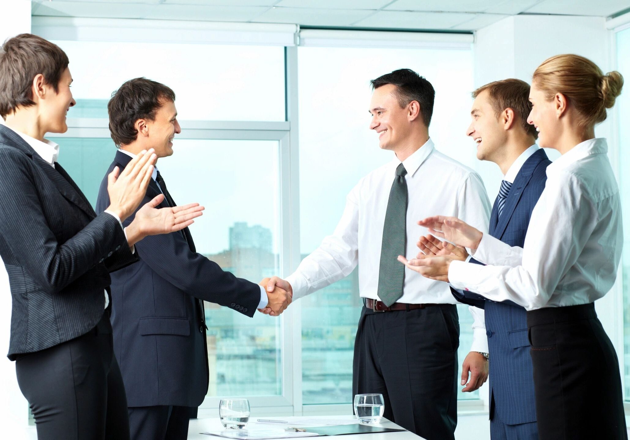 Business professionals shaking hands in an office meeting.